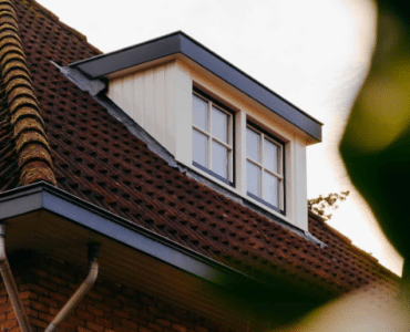 Houten dakkapel met dubbel raam op zolder.